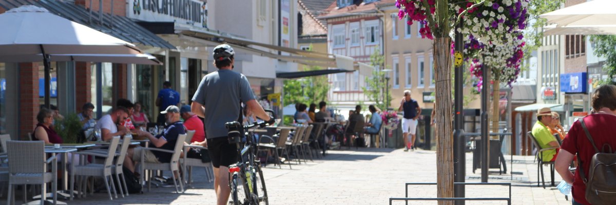 Ein Radfahrer schiebt sein Rad durch die Fußgängerzone