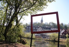 Ein Metallrahmen am Ederufer lädt zum Fotografieren der Stadtansicht ein