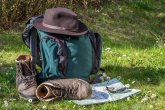 Wadnerrucksack und Wanderschuhe liegen auf einer Wiese