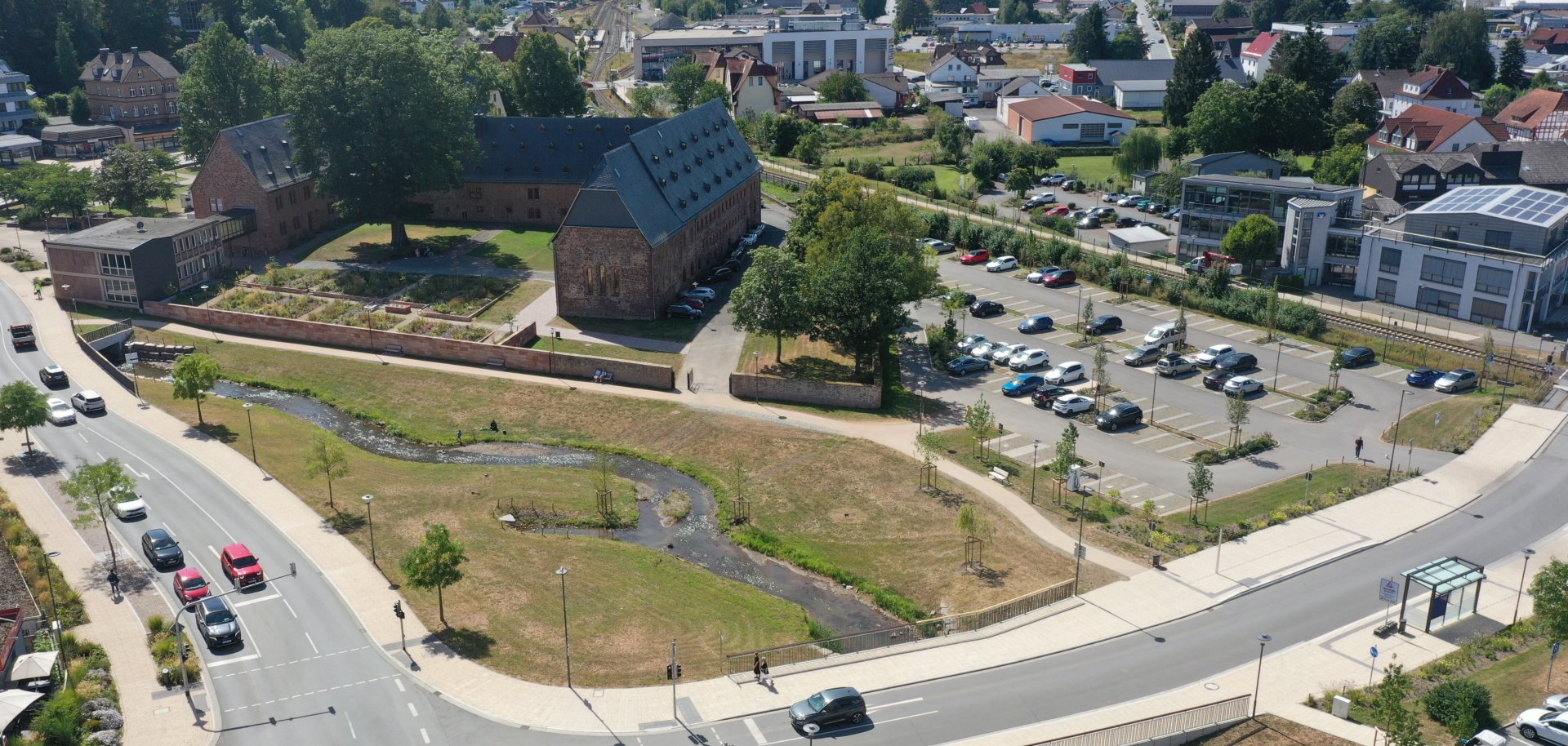 Luftaufnahme des Klosterumfelds mit Straßenkreuzung, einem Bachlauf und der Klosteranlage