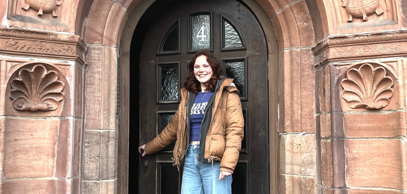 Junge Frau vor der leicht geöffneten Tür zum Studierenden-Wohnheim Collegium Philippinum