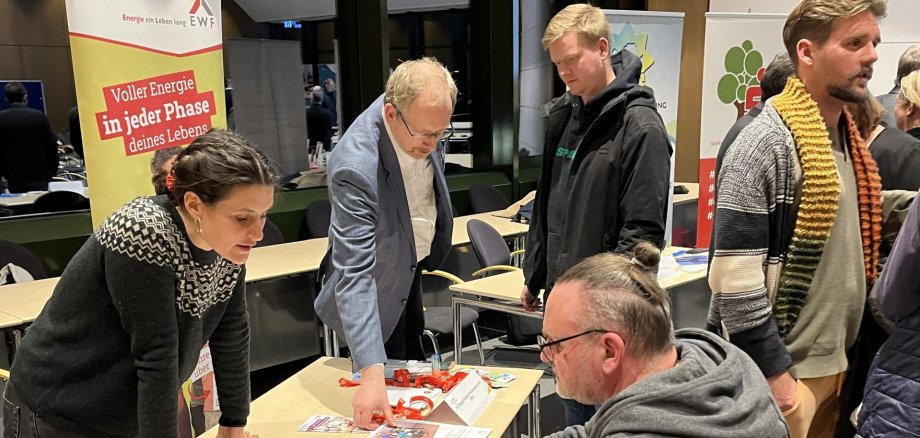 Mehrer Personen in Gesprächen an einem Messestand