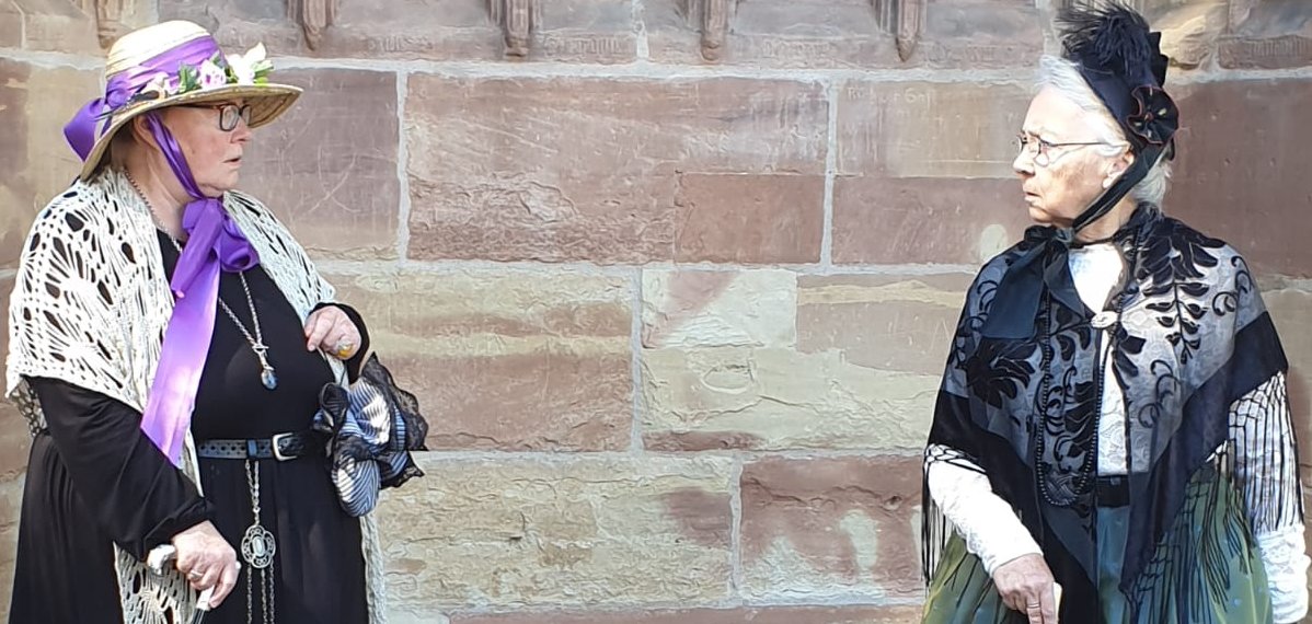 Zwei Frauen im Gespräch, gekleidet wie um 1900