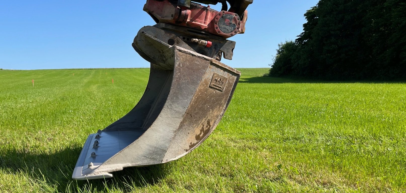 Baggerschaufel auf einer grünen Wiese