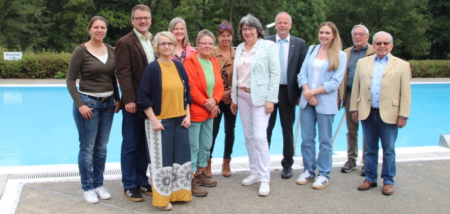 Gruppe von Männern und Frauen vor dem Schwimmbecken im Freibad Rengershausen