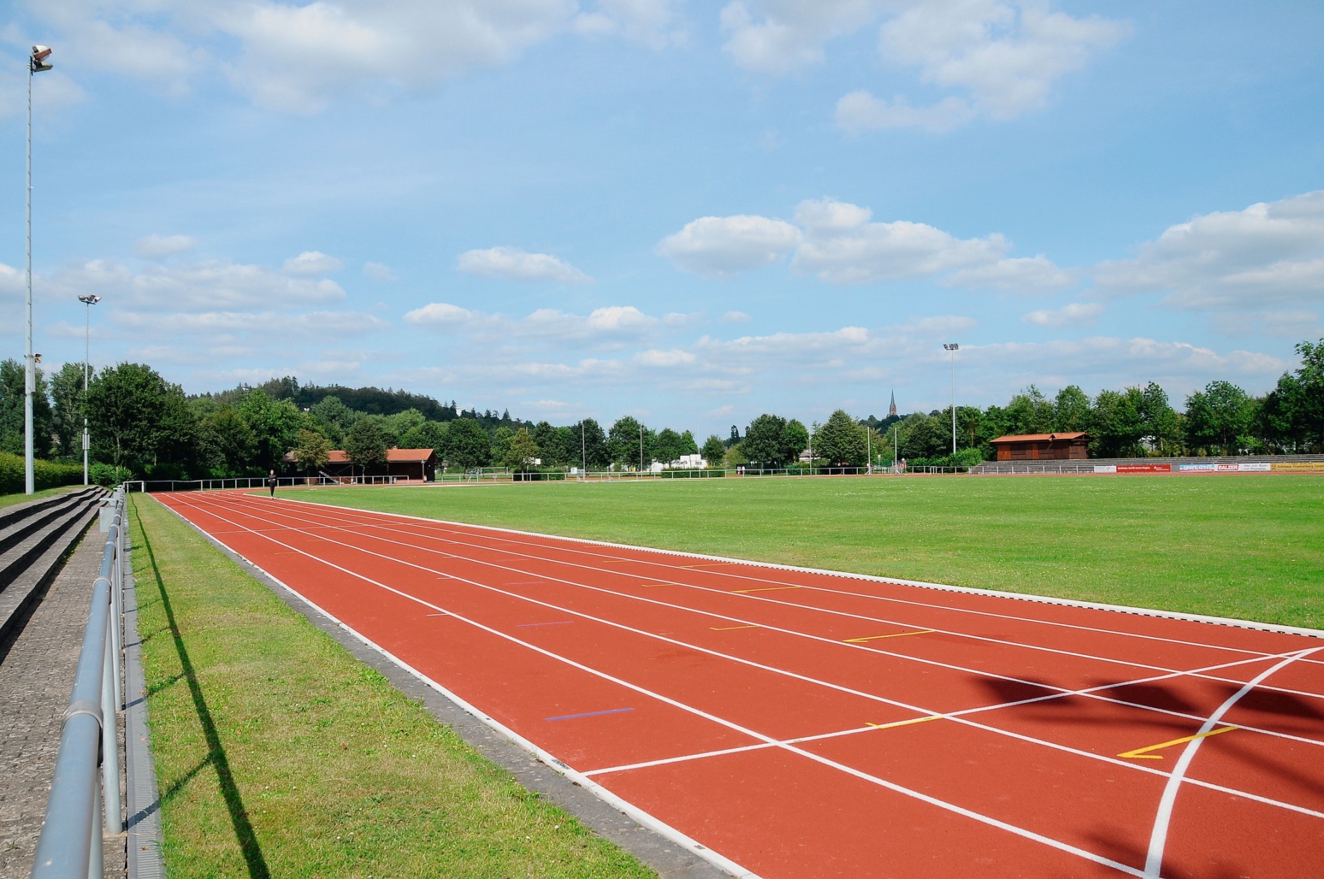 Laufbahn umgeben von grüner Wiese in einem Sportstadion