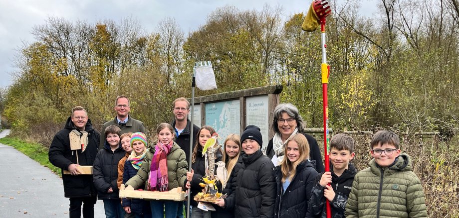 Gruppe aus Kindern und Erwachsenen steht vor einer Streuobstwiese